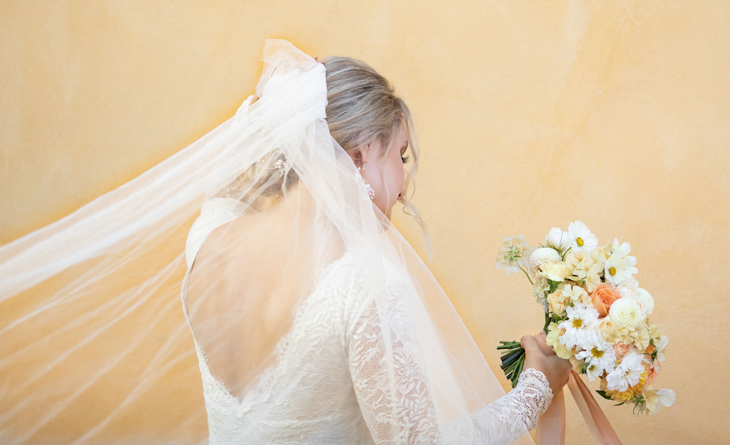 Brudklänning bakifrån med öppen rygg och slöja