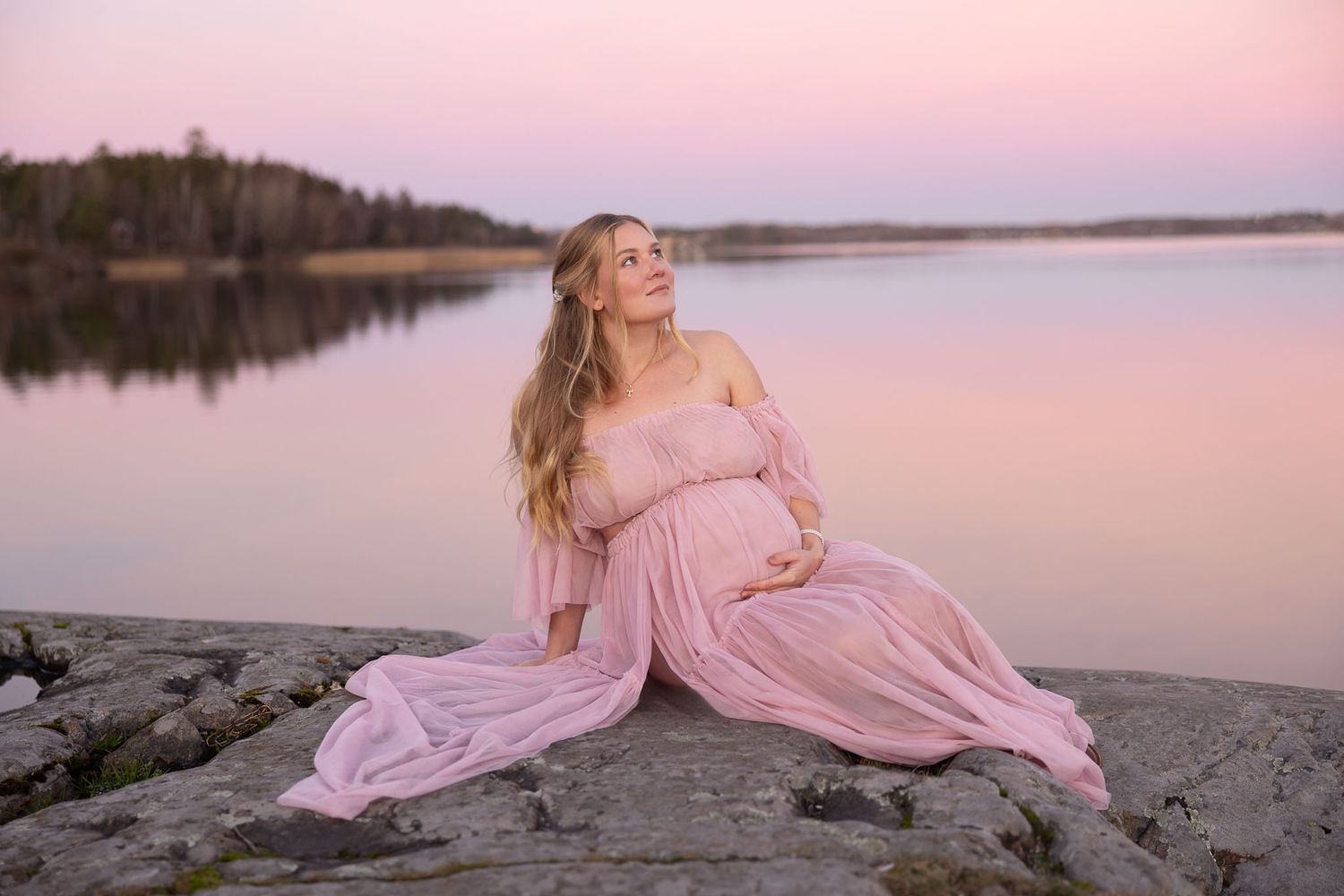 Gravid kvinna i solnedgång, rosa himmel