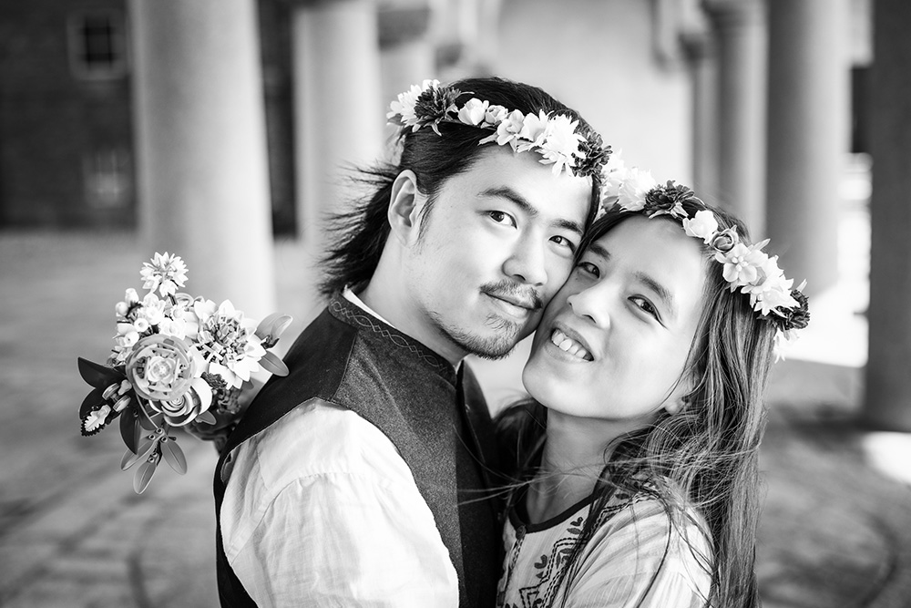 Brudpar med blomsterkransar i svartvitt